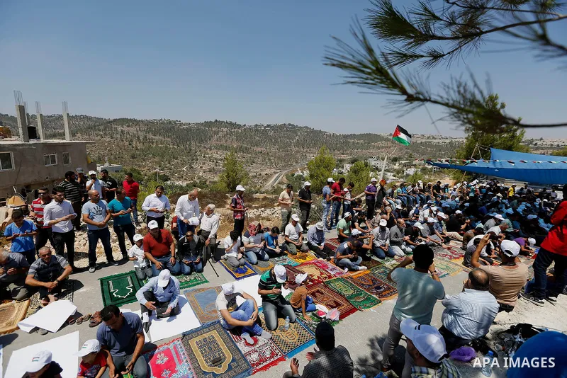 Palestinians take part in Friday prayer before a protest against alerts of the Israeli army to demolish houses, in the West Bank village of Walajeh, near Bethlehem, August 18, 2017. Photo by Wisam Hashlamoun