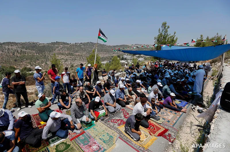 Palestinians take part in Friday prayer before a protest against alerts of the Israeli army to demolish houses, in the West Bank village of Walajeh, near Bethlehem, August 18, 2017. Photo by Wisam Hashlamoun
