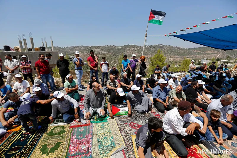 Palestinians take part in Friday prayer before a protest against alerts of the Israeli army to demolish houses, in the West Bank village of Walajeh, near Bethlehem, August 18, 2017. Photo by Wisam Hashlamoun