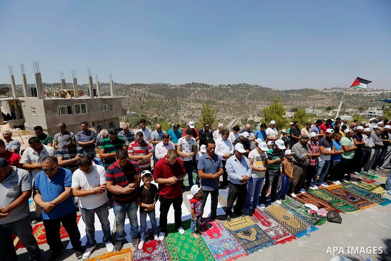Palestinians take part in Friday prayer before a protest against alerts of the Israeli army to demolish houses, in the West Bank village of Walajeh, near Bethlehem, August 18, 2017. Photo by Wisam Hashlamoun