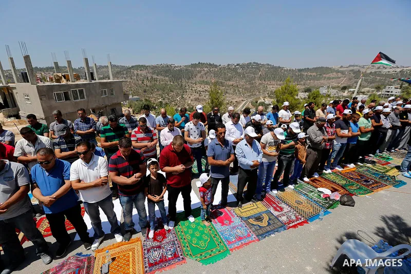 Palestinians take part in Friday prayer before a protest against alerts of the Israeli army to demolish houses, in the West Bank village of Walajeh, near Bethlehem, August 18, 2017. Photo by Wisam Hashlamoun