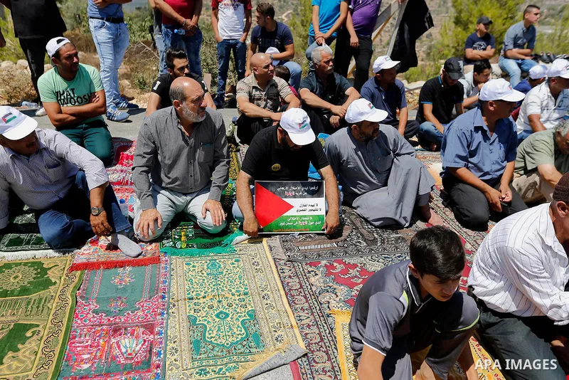 Palestinians take part in Friday prayer before a protest against alerts of the Israeli army to demolish houses, in the West Bank village of Walajeh, near Bethlehem, August 18, 2017. Photo by Wisam Hashlamoun