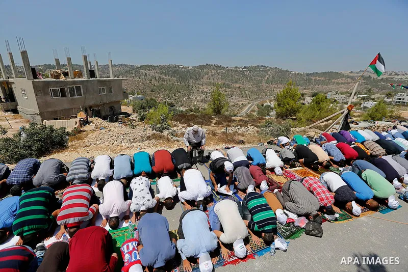 Palestinians take part in Friday prayer before a protest against alerts of the Israeli army to demolish houses, in the West Bank village of Walajeh, near Bethlehem, August 18, 2017. Photo by Wisam Hashlamoun