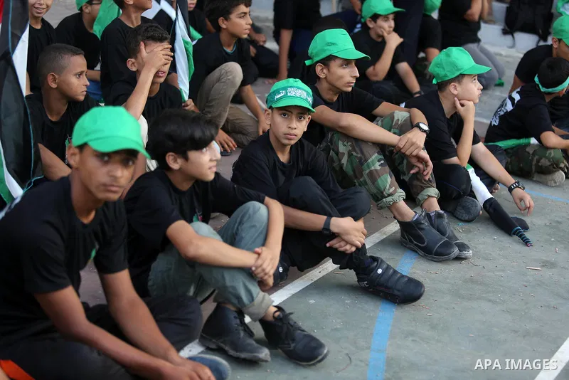Palestinian youths take part in a military graduation ceremony at a Hamas summer camp in al-Bureij in the central of Gaza strip, August 20, 2017. Photo by Ashraf Amra