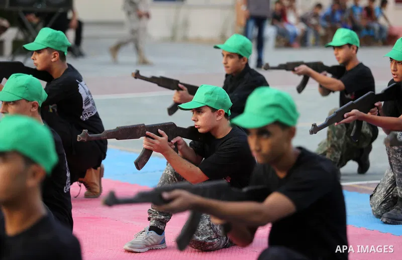 Palestinian youths take part in a military graduation ceremony at a Hamas summer camp in al-Bureij in the central of Gaza strip, August 20, 2017. Photo by Ashraf Amra