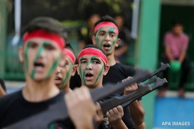 Palestinian youths take part in a military graduation ceremony at a Hamas summer camp in al-Bureij in the central of Gaza strip, August 20, 2017. Photo by Ashraf Amra