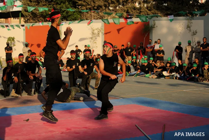 Palestinian youths take part in a military graduation ceremony at a Hamas summer camp in al-Bureij in the central of Gaza strip, August 20, 2017. Photo by Ashraf Amra
