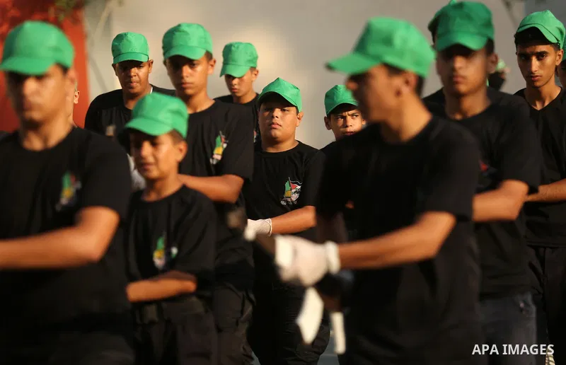 Palestinian youths take part in a military graduation ceremony at a Hamas summer camp in al-Bureij in the central of Gaza strip, August 20, 2017. Photo by Ashraf Amra