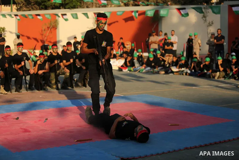 Palestinian youths take part in a military graduation ceremony at a Hamas summer camp in al-Bureij in the central of Gaza strip, August 20, 2017. Photo by Ashraf Amra