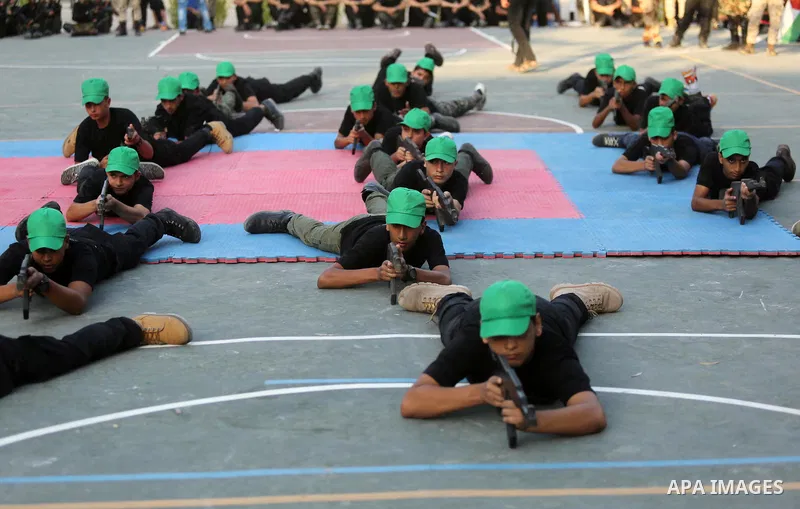 Palestinian youths take part in a military graduation ceremony at a Hamas summer camp in al-Bureij in the central of Gaza strip, August 20, 2017. Photo by Ashraf Amra