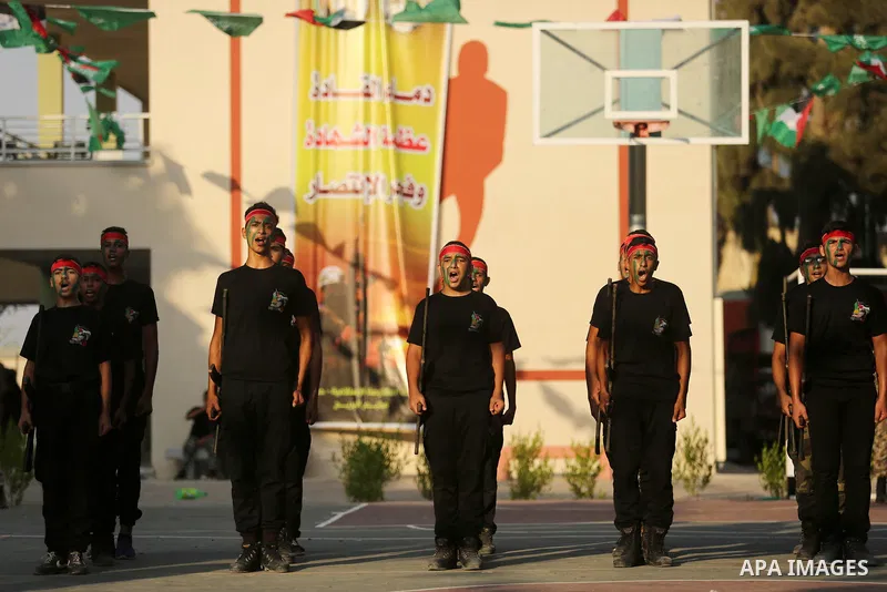 Palestinian youths take part in a military graduation ceremony at a Hamas summer camp in al-Bureij in the central of Gaza strip, August 20, 2017. Photo by Ashraf Amra