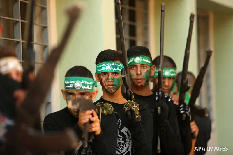 Palestinian youths take part in a military graduation ceremony at a Hamas summer camp in al-Bureij in the central of Gaza strip, August 20, 2017. Photo by Ashraf Amra