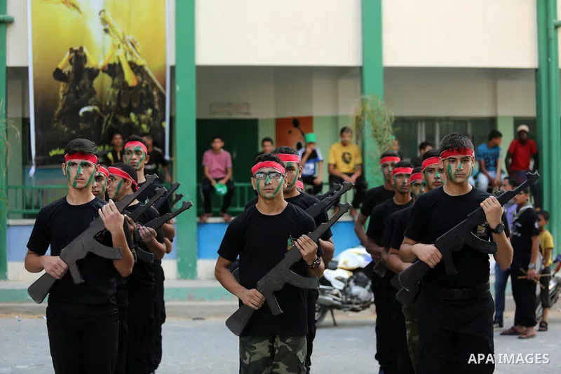 Palestinian youths take part in a military graduation ceremony at a Hamas summer camp in al-Bureij in the central of Gaza strip, August 20, 2017. Photo by Ashraf Amra