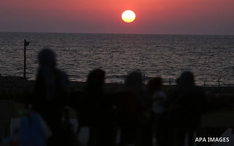 Palestinians enjoy a day at the beach of the Mediterranean sea in Gaza city during sunset, on August 20, 2017. Photo by Ashraf Amra