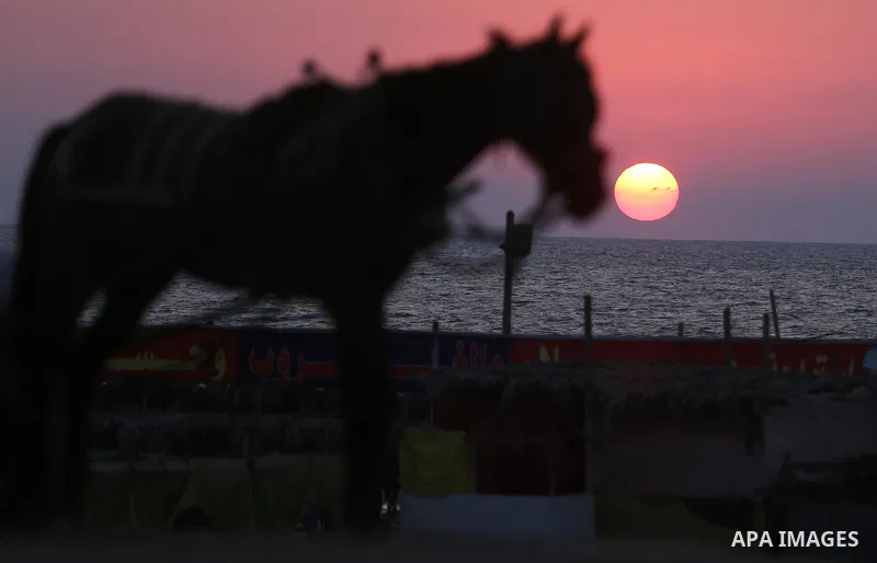 The sunset is seen from the beach of the Mediterranean Sea in Gaza City, on August 20, 2017. Photo by Ashraf Amra