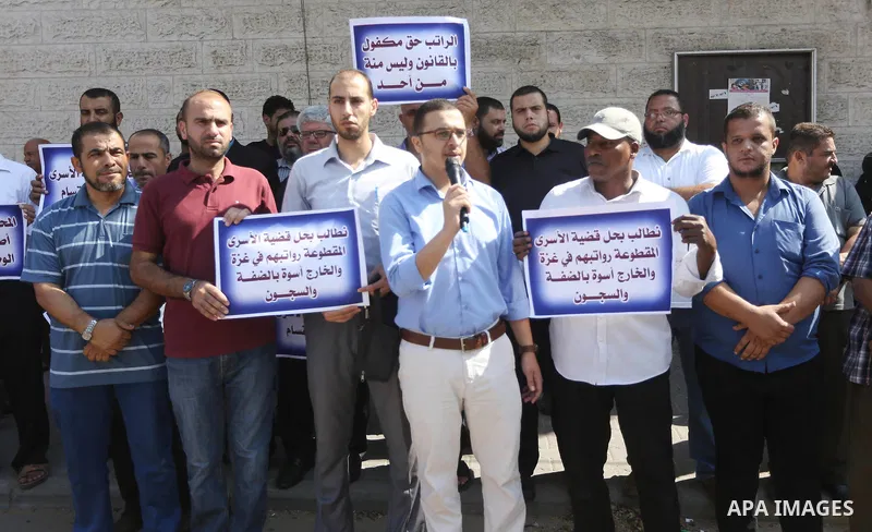 Palestinian hold banners during a protest to show solidarity with Palestinian Prisoner held in Israeli jails, in front of Red cross office, in Gaza city on August 21, 2017. Photo by Mohammed Asad