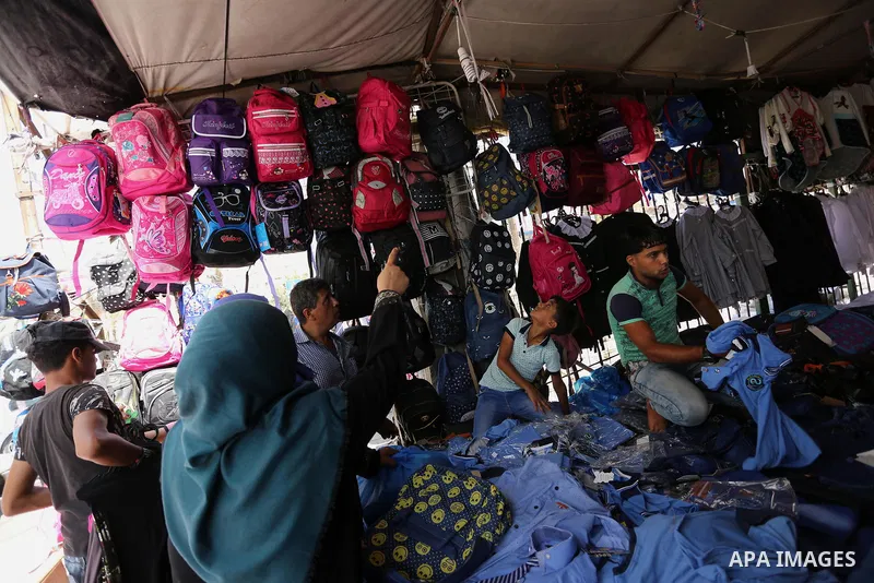 Palestinians shop during preparation for the new school year at a market in Gaza city, on August 21, 2017. Photo by Ashraf Amra