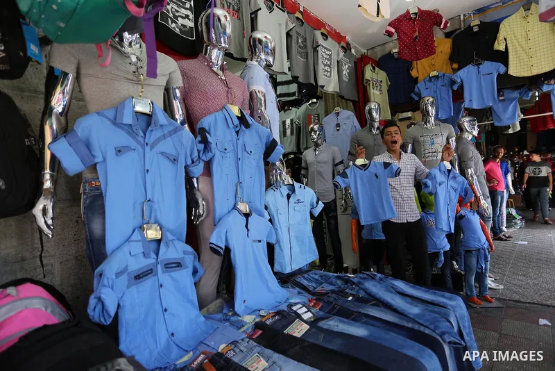 Palestinians shop during preparation for the new school year at a market in Gaza city, on August 21, 2017. Photo by Ashraf Amra