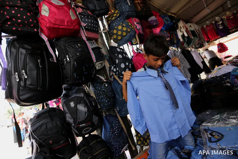 Palestinians shop during preparation for the new school year at a market in Gaza city, on August 21, 2017. Photo by Ashraf Amra