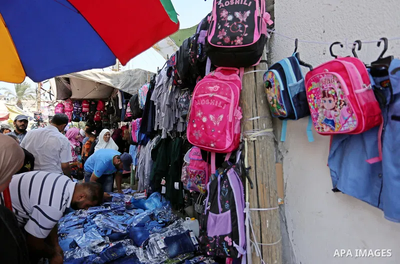 Palestinians shop during preparation for the new school year at a market in Gaza city, on August 21, 2017. Photo by Ashraf Amra