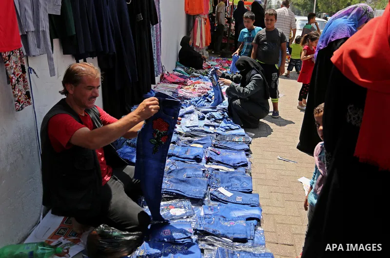 Palestinians shop during preparation for the new school year at a market in Gaza city, on August 21, 2017. Photo by Ashraf Amra