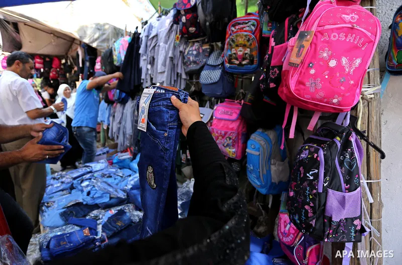 Palestinians shop during preparation for the new school year at a market in Gaza city, on August 21, 2017. Photo by Ashraf Amra