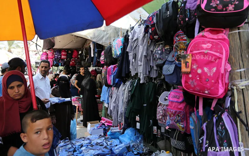 Palestinians shop during preparation for the new school year at a market in Gaza city, on August 21, 2017. Photo by Ashraf Amra