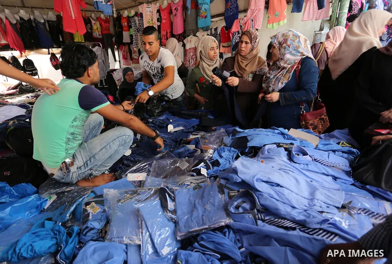 Palestinians shop during preparation for the new school year at a market in Gaza city, on August 21, 2017. Photo by Ashraf Amra
