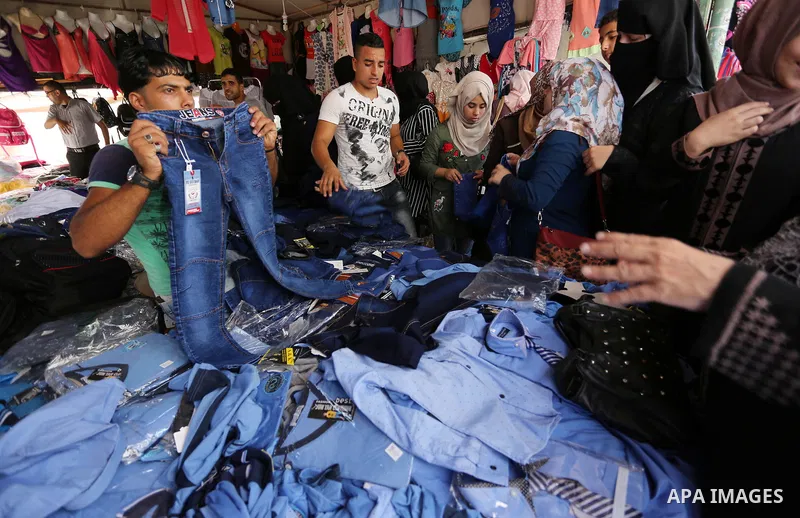 Palestinians shop during preparation for the new school year at a market in Gaza city, on August 21, 2017. Photo by Ashraf Amra