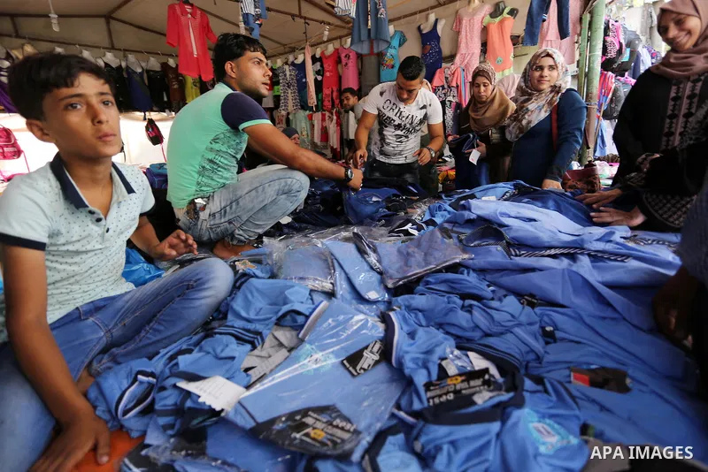 Palestinians shop during preparation for the new school year at a market in Gaza city, on August 21, 2017. Photo by Ashraf Amra