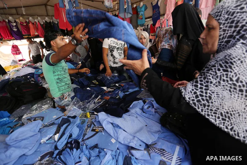 Palestinians shop during preparation for the new school year at a market in Gaza city, on August 21, 2017. Photo by Ashraf Amra