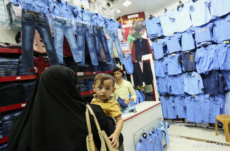 Palestinians shop during preparation for the new school year at a market in Gaza city, on August 21, 2017. Photo by Ashraf Amra