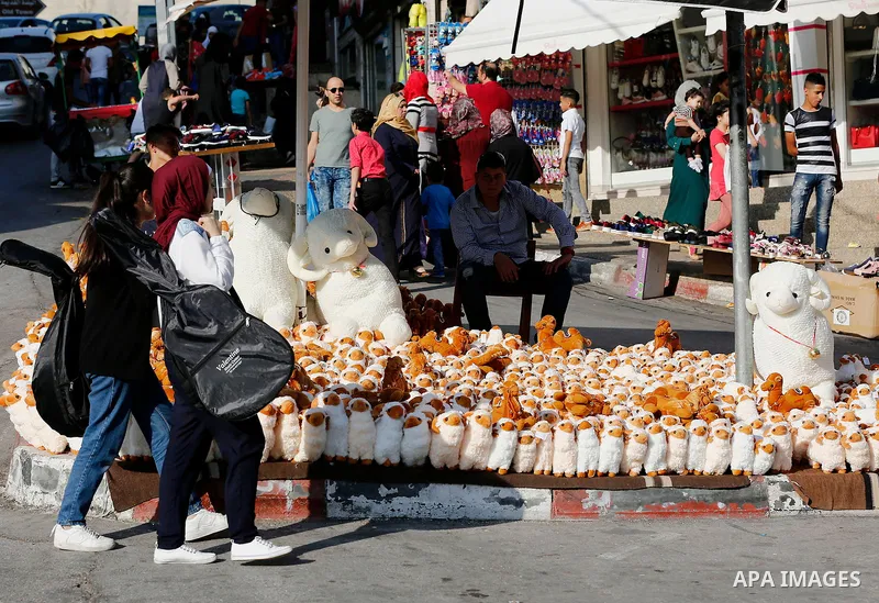 A Palestinian vendor displays toys of sheep at a market ahead of the Eid al-Adha festival in the West Bank city of Hebron, on August 21, 2017. Photo by Wisam Hashlamoun