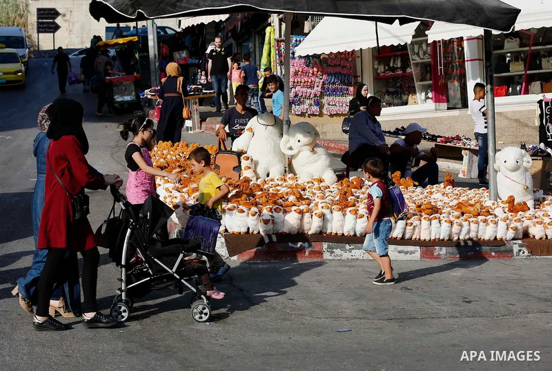 A Palestinian vendor displays toys of sheep at a market ahead of the Eid al-Adha festival in the West Bank city of Hebron, on August 21, 2017. Photo by Wisam Hashlamoun