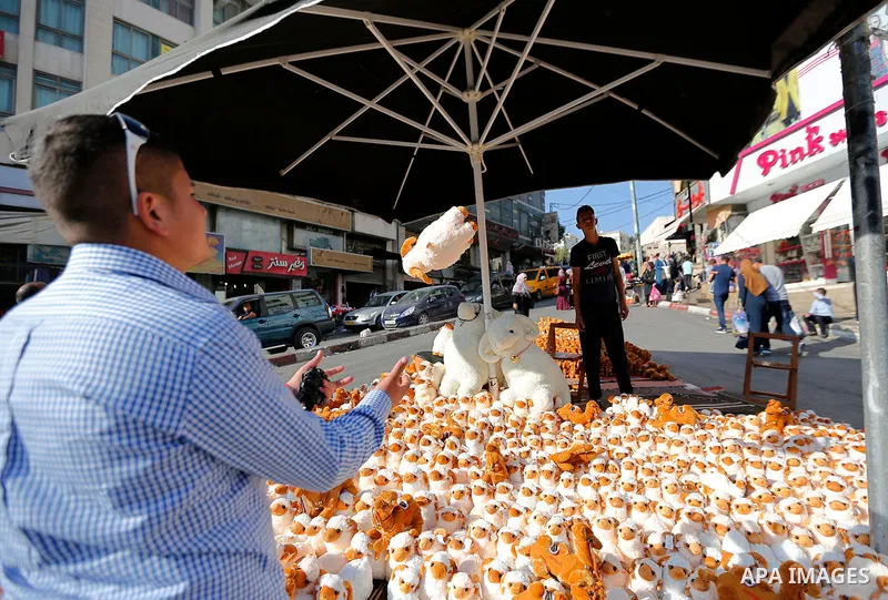 A Palestinian vendor displays toys of sheep at a market ahead of the Eid al-Adha festival in the West Bank city of Hebron, on August 21, 2017. Photo by Wisam Hashlamoun