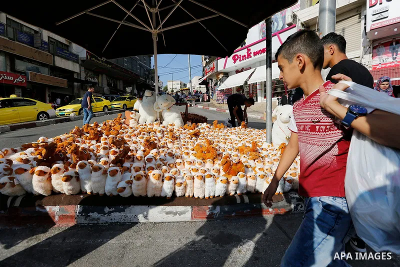 A Palestinian vendor displays toys of sheep at a market ahead of the Eid al-Adha festival in the West Bank city of Hebron, on August 21, 2017. Photo by Wisam Hashlamoun
