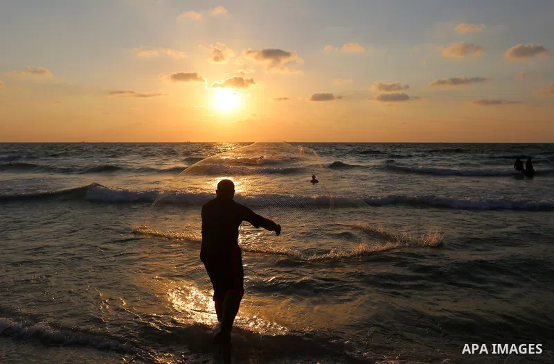 Palestinian fisherman Jihad al-Soltan prepares his fishing net on a beach in the northern Gaza Strip August 21, 2017. Photo by Yasser Qudih