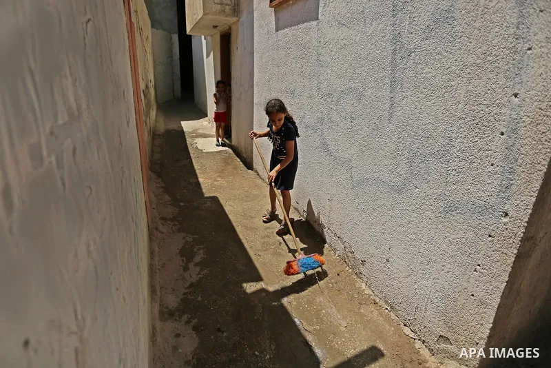 A Palestinian girl cleans outside her house at el-shate refugee camp in Gaza, on August 22, 2017. Photo by Ashraf Amra