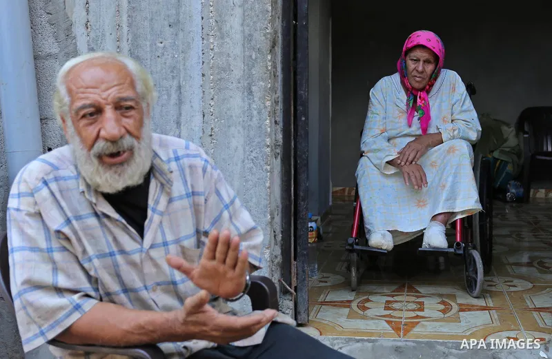 Palestinians sit outside their house at el-shate refugee camp in Gaza, on August 22, 2017. Photo by Ashraf Amra
