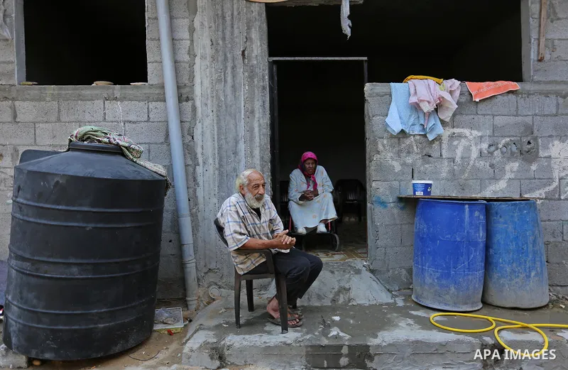 Palestinians sit outside their house at el-shate refugee camp in Gaza, on August 22, 2017. Photo by Ashraf Amra