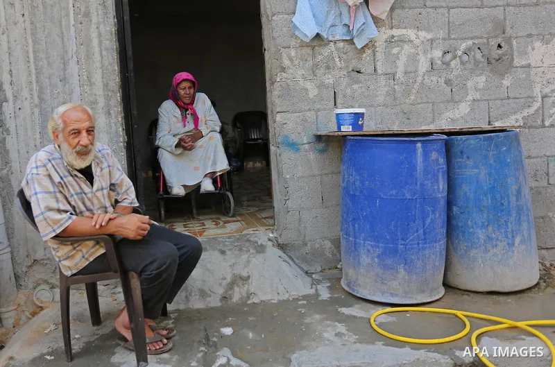 Palestinians sit outside their house at el-shate refugee camp in Gaza, on August 22, 2017. Photo by Ashraf Amra