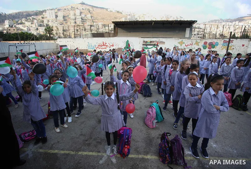 Palestinian schoolchildren play on the first day of a new school year, at a school in the West bank city of Nablus August 23, 2017. Photo by Ayman Ameen