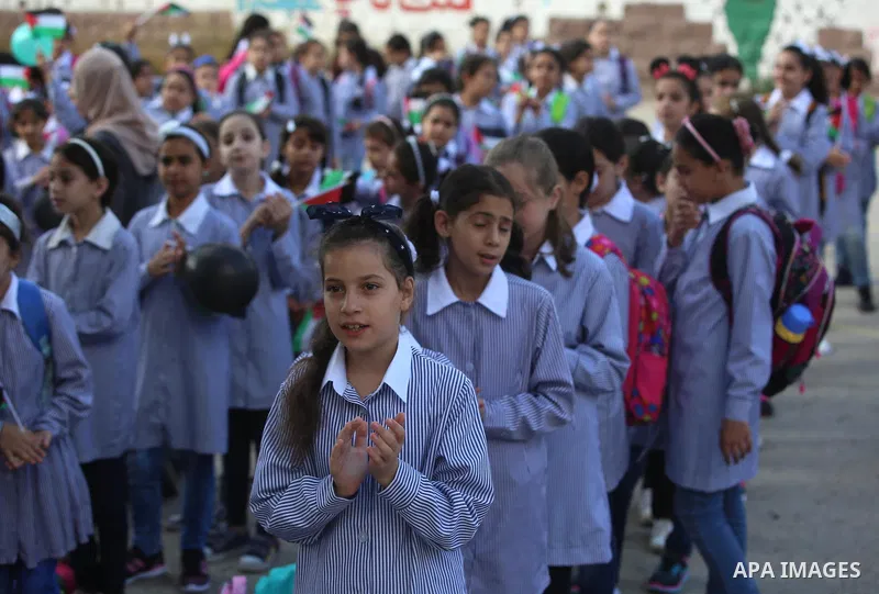 Palestinian schoolchildren stand in a line on the first day of a new school year, at a school in the West bank city of Nablus August 23, 2017. Photo by Ayman Ameen