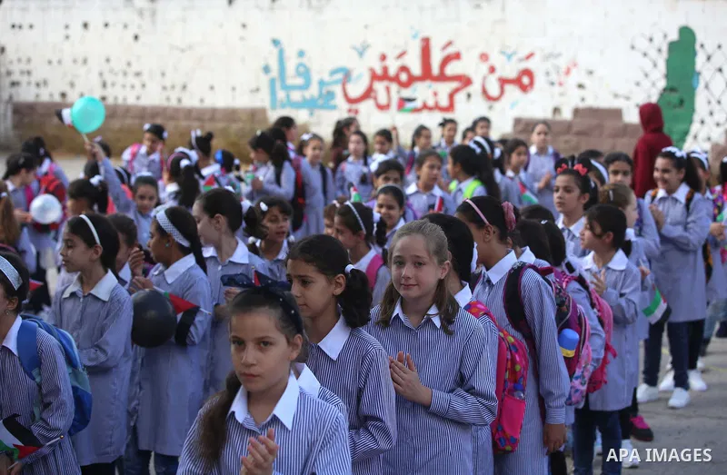 Palestinian schoolchildren stand in a line on the first day of a new school year, at a school in the West bank city of Nablus August 23, 2017. Photo by Ayman Ameen