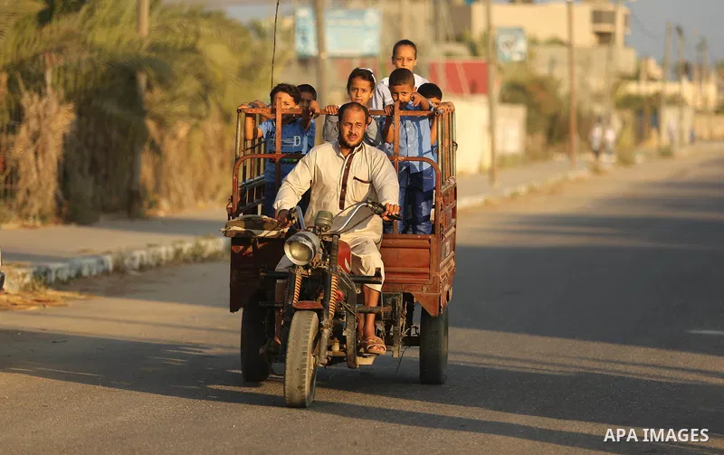 Palestinian schoolchildren ride motorcycle as they make their way to school on the first day of a new school year, at a United Nations-run school in Deir al-Balah refugee camp in the central Gaza Strip August 23, 2017. P...