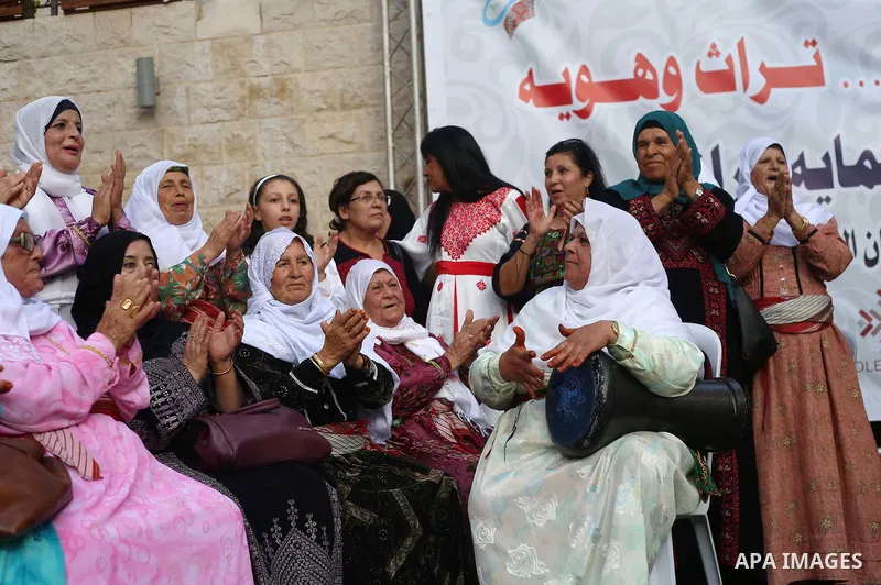 Palestinians wear a traditional costumes, attend a festival marking Traditional Palestinian Dress Day, in the West Bank city of Nablus on August 22, 2017. Photo by Ayman Ameen