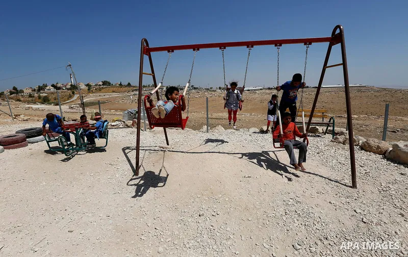 Palestinian schoolchildren play as the return back to their school in the morning of the first day of the new year study, in the village of Susya south of the West Bank city of Hebron on August 23, 2017. Photo by Wisam H...