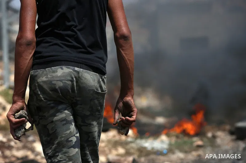 A Palestinian protester holds stones during clashes with Israeli security forces following a weekly demonstration against the expropriation of Palestinian land by Israel in the village of Kfar Qaddum, near Nablus in the...