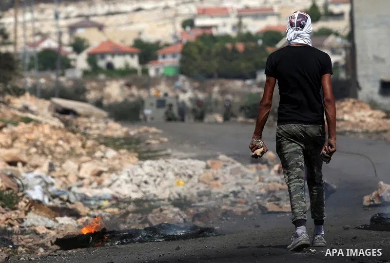 A Palestinian protester holds stones during clashes with Israeli security forces following a weekly demonstration against the expropriation of Palestinian land by Israel in the village of Kfar Qaddum, near Nablus in the...