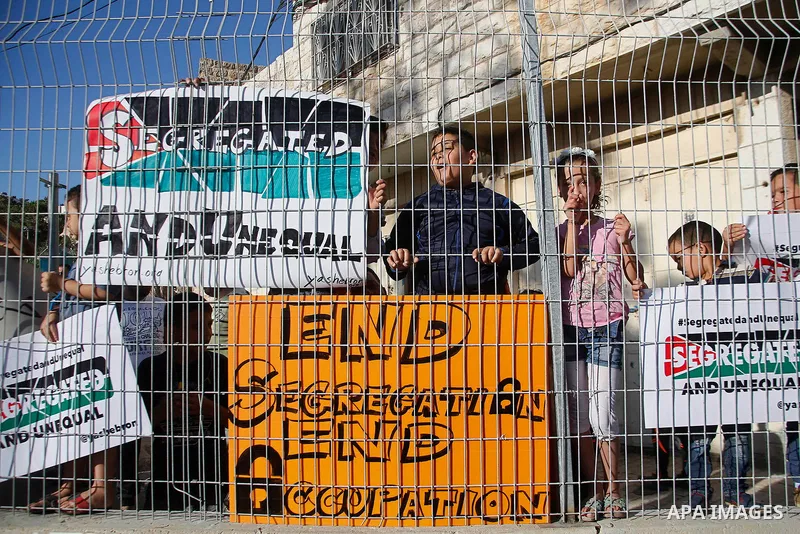 Palestinian protesters hold placards during a protest against new gates and barriers near the near the Ibrahimi mosque in the Old city of the West Bank city of Hebron on August 28, 2017. Photo by Wisam Hashlamoun